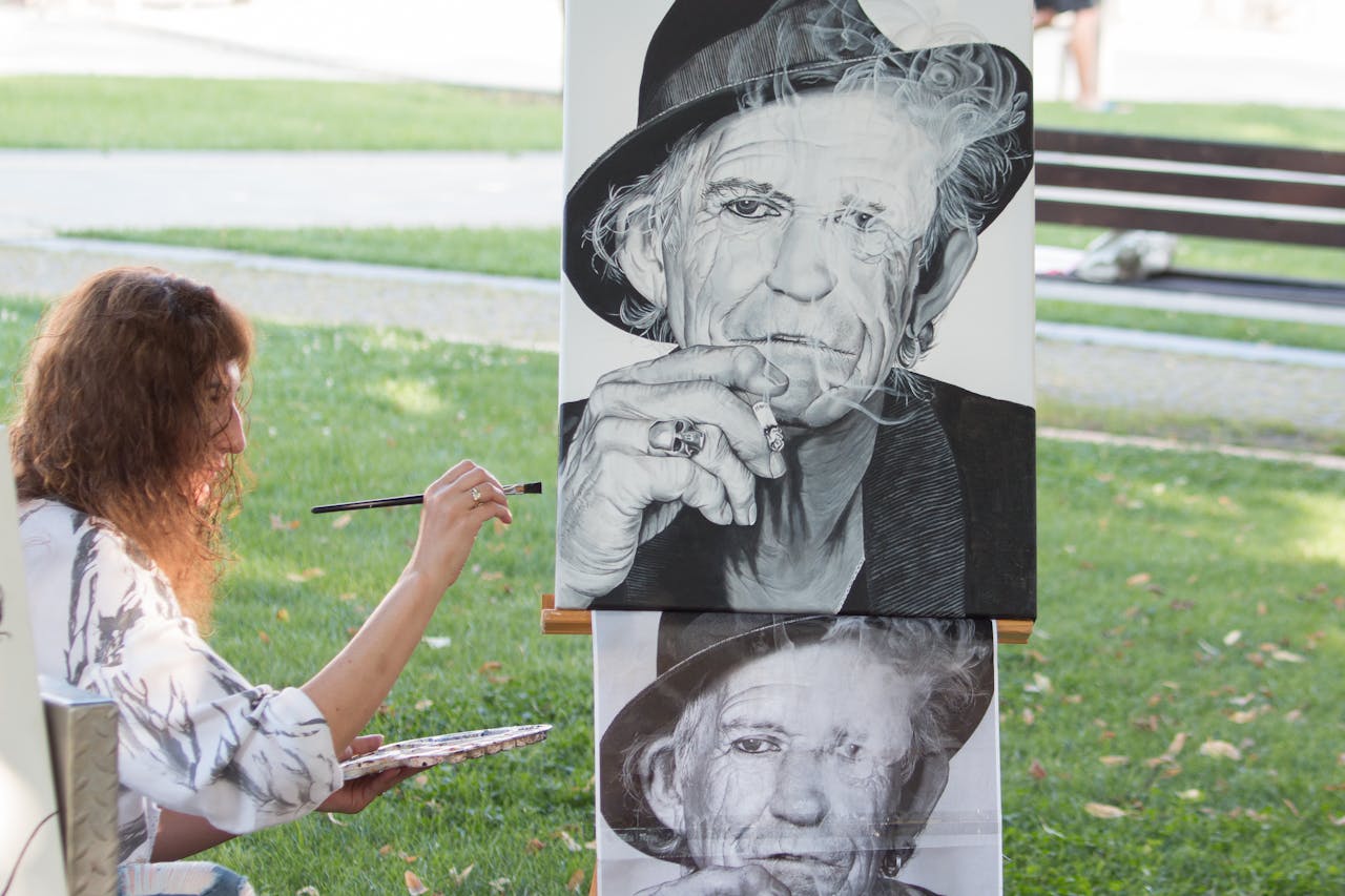 about-us-01 Woman artist painting a portrait in Zvolen park on a sunny day.